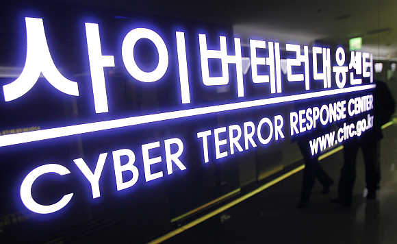 Police officers of the Cyber Terror Response Centre are reflected as they walk out of their office at the headquarters of the National Police Agency in Seoul, South Korea.