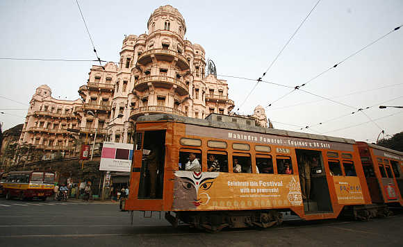 A tram passes beside a heritage building in Kolkata.