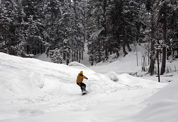 A man snow boards down a slope in Gulmarg, 55km west of Srinagar.