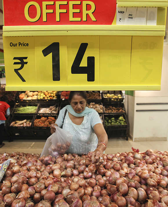 A woman selects onions in the fresh foods section of a Reliance Fresh supermarket in Mumbai.
