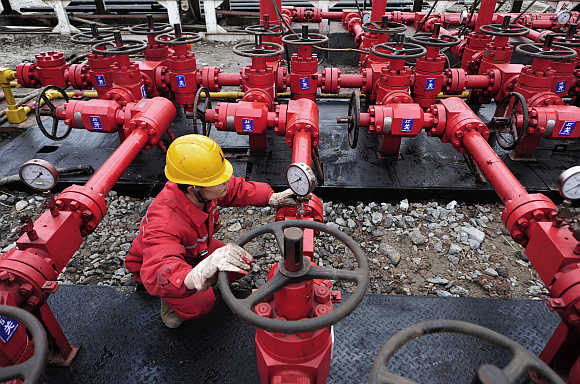 A worker performs a routine check to the valves at a natural gas appraisal well of Sinopec in Langzhong county, Sichuan province, China.