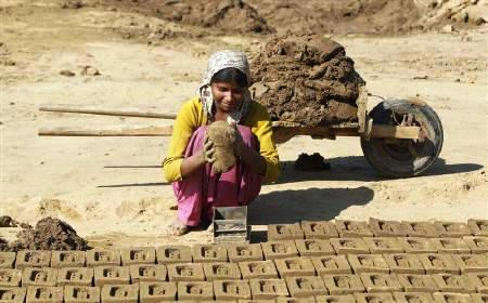 A woman labourer works in a brick factory at Libbar Hari in Uttarakhand.