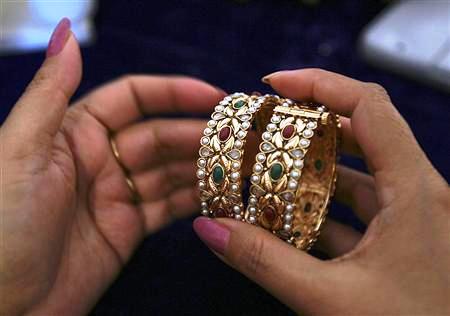A customer selects one-carat gold bangles during an exhibition in Jammu.