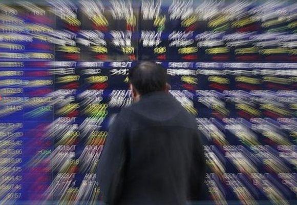A man looks at a stock index board outside a brokerage in Tokyo.