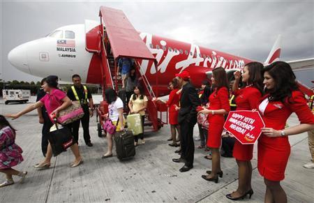 AirAsia staff greet passengers arriving from Kota Kinabalu to the Low Cost Carrier Terminal in Sepang outside Kuala Lumpur.
