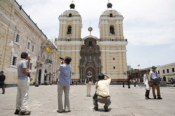 Tourists take pictures of the San Francisco Monastery in Lima, Peru.