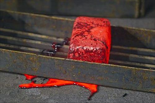 A hot poured gold alloy bar which has been turned out from a mould is seen in a workshop at Kumtor gold mine extraction factory.