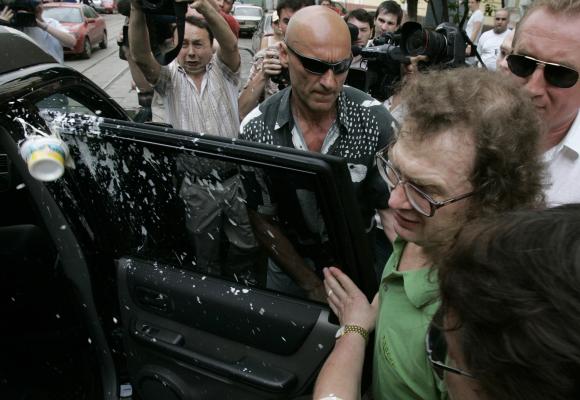 Sour cream is thrown at Sergey Mavrodi (in green shirt), former head of a collapsed 1990s investment scheme, as he gets into a car after leaving prison in Moscow.