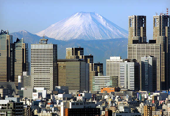Mt Fuji, covered with snow, is seen through Shinjuku skyscrapers in Tokyo, Japan.