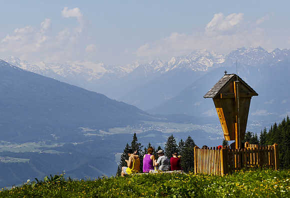 People people enjoy the view from the Bettelwurf mountain on a sunny summer day in the western Austrian village of Absam.