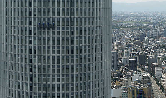 Workers clean the windows of a high rise building at the Nagoya station in Nagoya, central Japan.