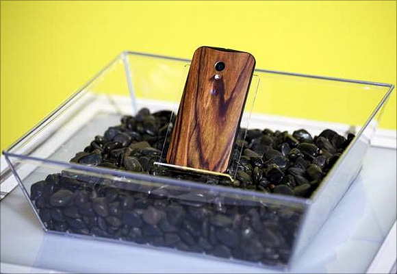 A phone with a wooden back on it rests in a display.