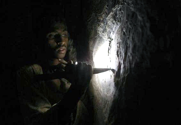 Gold mine workers walk to their shelter during a sandstorm in Al-Ibedia locality at River Nile State.