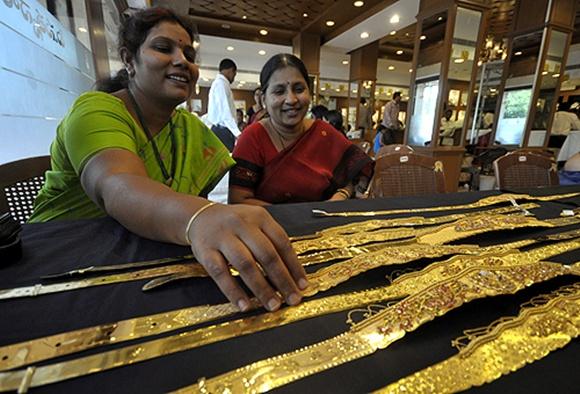 A woman checks a gold waist belt inside a jewellery shop in Hyderabad.