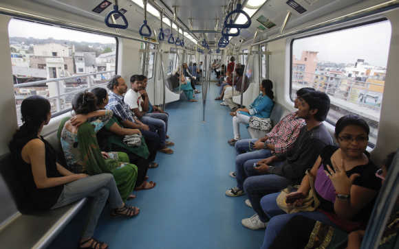 Commuters ride inside a carriage of a Namma Metro train as it travels along an elevated track in the Indira Nagar area of Bangalore.