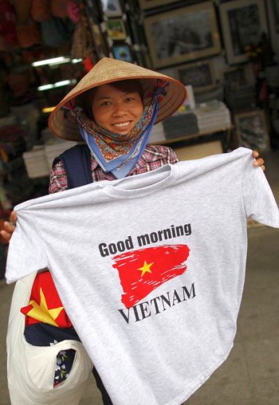 A street vendor shows a T-shirt for sale in the old quarter of Hanoi.