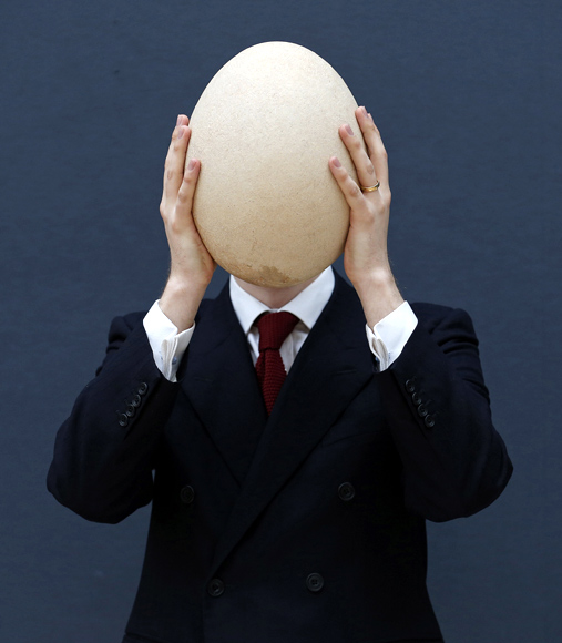 Christie's specialist James Hyslop holds a pre-17th century, sub-fossilised Elephant Bird egg in London.