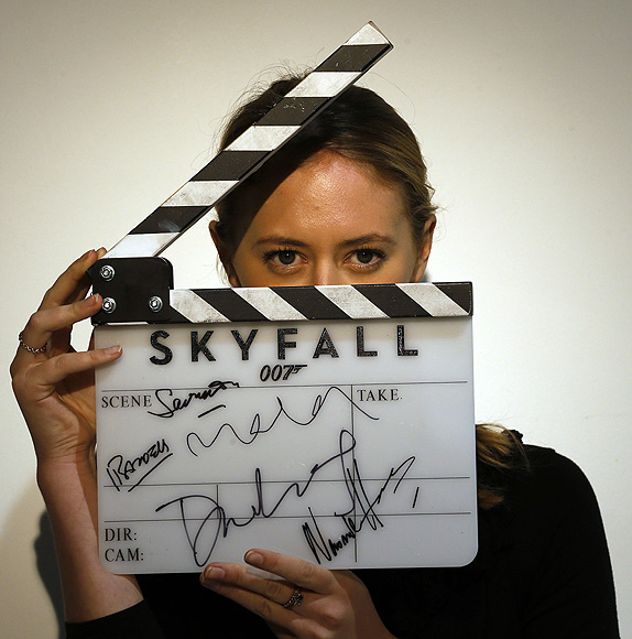 A worker holds a clapperboard from the film Skyfall during a media preview of 50 Years of James Bond - the Auction, at Christie's in London.