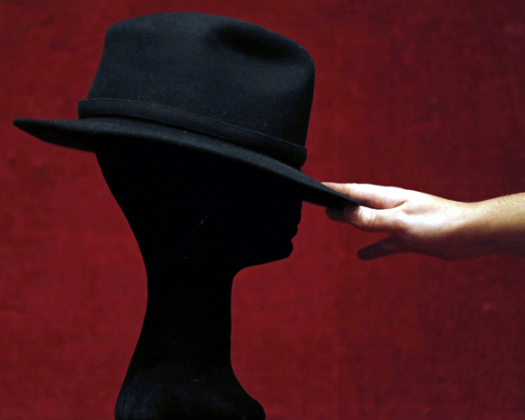 An assistant displays a black Fedora hat owned by late singer Michael Jackson at Drouot auction house in Paris.