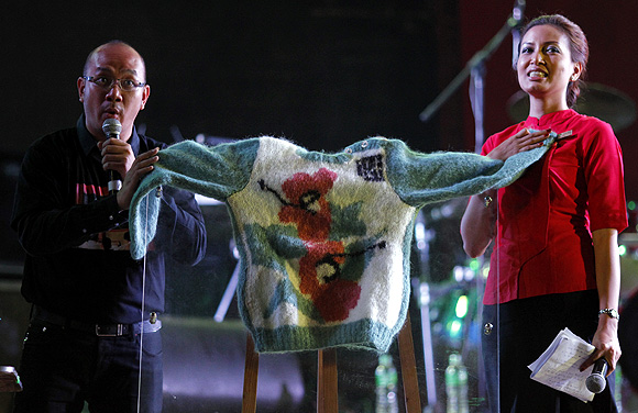 Presenters show a sweater made by Myanmar pro-democracy leader Aung San Suu Kyi over 20 years ago, as they prepare for an auction during a Fund Raising campaign for Education Network of her NLD party at Yangon.