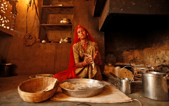 Laxmi, 34, who works as a construction labourer, prepares a roti inside her house at Merta district in Rajasthan. 