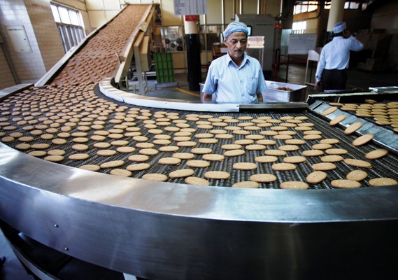 A worker stands next to a production line at the Britannia biscuit factory in New Delhi.
