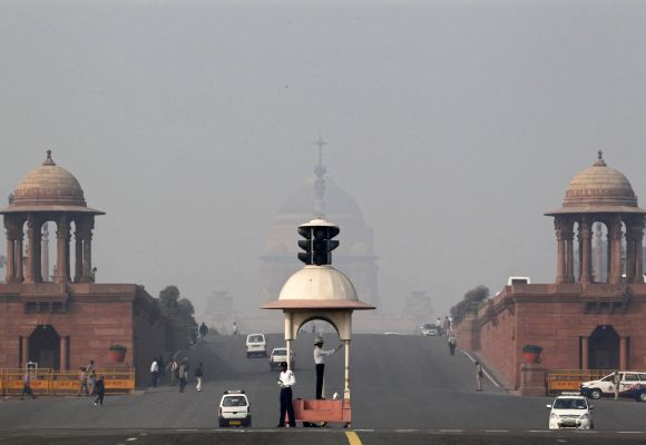 A traffic police officer directs traffic in front of India's presidential palace Rashtrapati Bhavan amid dense smog in New Delhi.