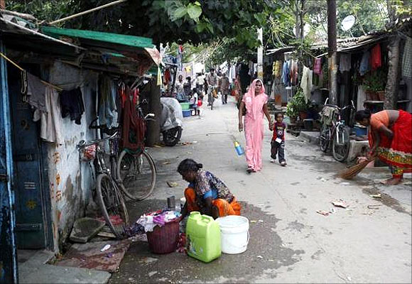 A woman washes clothes outside her house at a slum in New Delhi.