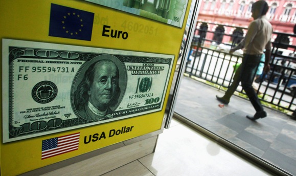 A man walks past a board advertising US dollars at a money exchange shop in Colombo.