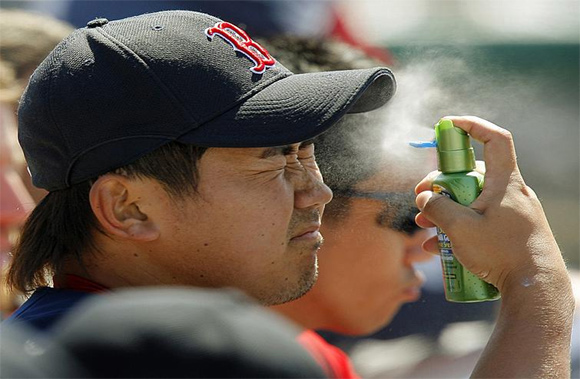 Red Sox pitcher Daisuke Matsuzaka sprays sunscreen on his face during a spring training game against the Dodgers in Vero Beach, Fla.