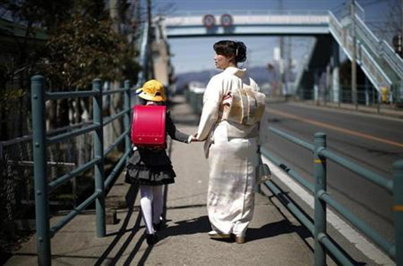A girl walks with her mother after her first day of school at the Shimizu elementary school in Fukushima, northern Japan.
