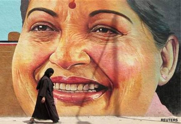 A woman walks past a portrait of J. Jayalalithaa, Chief Minister of the southern Indian state of Tamil Nadu.