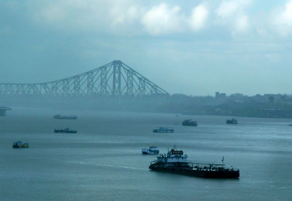 A passenger boat moves along the Hooghly river after passing under the Howrah bridge during a monsoon shower in the eastern Indian city of Kolkata.