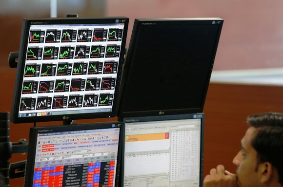 A broker monitors a screen displaying live stock quotes on the floor of a trading firm in Mumbai.