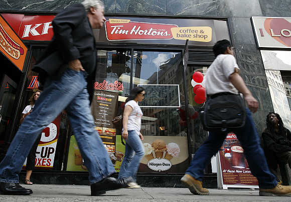 Pedestrians walk past Tim Hortons coffee and bake shop in Midtown Manhattan section of New York.