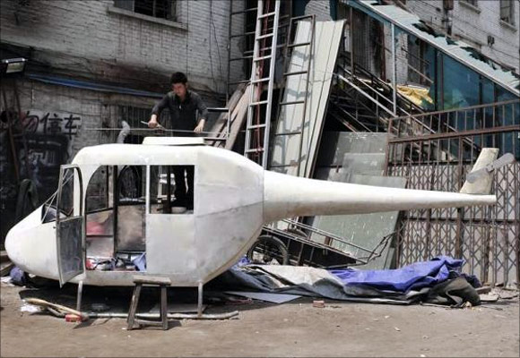 Gao Hanjie installs the rotor blades on his homemade helicopter in Shenyang, Liaoning province, China.