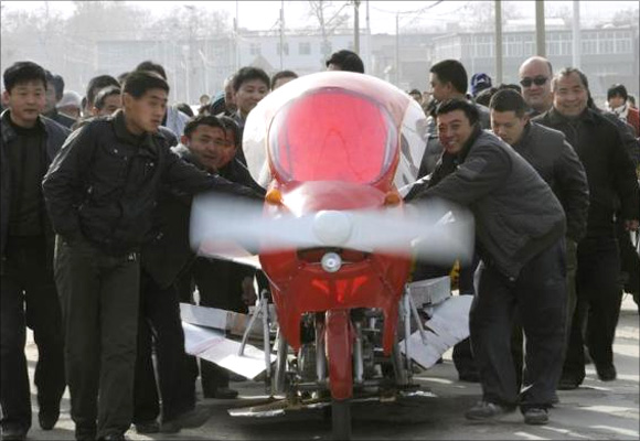 Villagers help to push Zhang Xuelin's self-made aircraft before its test flight in Jinan, Shandong province.