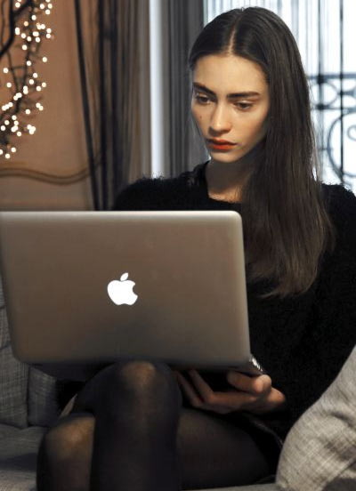 French top model Marine Deleeuw browsing internet on her laptop.