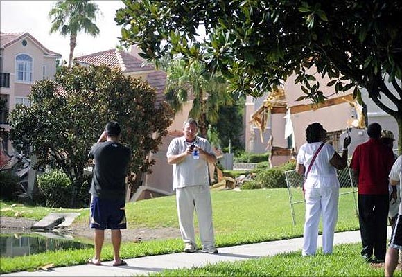 Bystanders photograph a section of the Summer Bay Resort after a large sinkhole opened on the property's grounds, in Clermont, Florida.