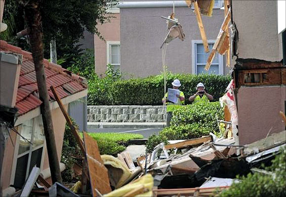 Bystanders photograph a section of the Summer Bay Resort after a large sinkhole opened on the property's grounds, in Clermont, Florida.