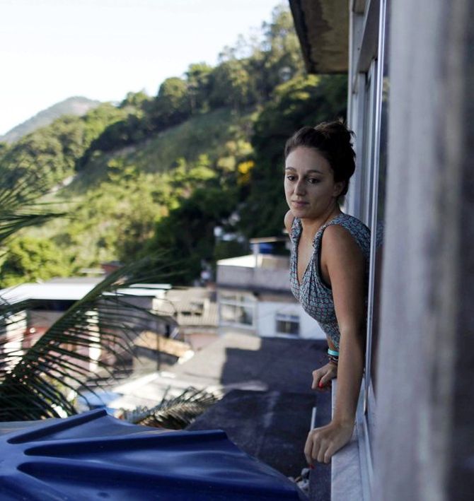 French student Melodie Valerio looks out the window of her rented room in the Pereira da Silva slum in Rio de Janeiro.