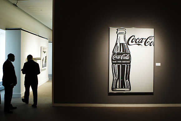 Security guards stand near 'Coca-Cola [4] Large Coca-Cola' by Andy Warhol during a preview of Sotheby's Impressionist & Modern Art auction in New York.
