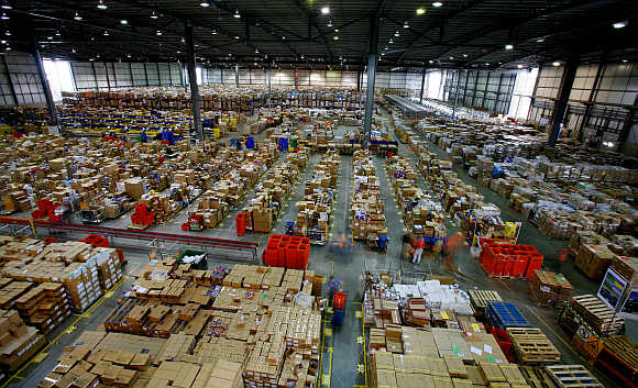 Workers sort through packages at the Amazon warehouse in Milton Keynes in England.