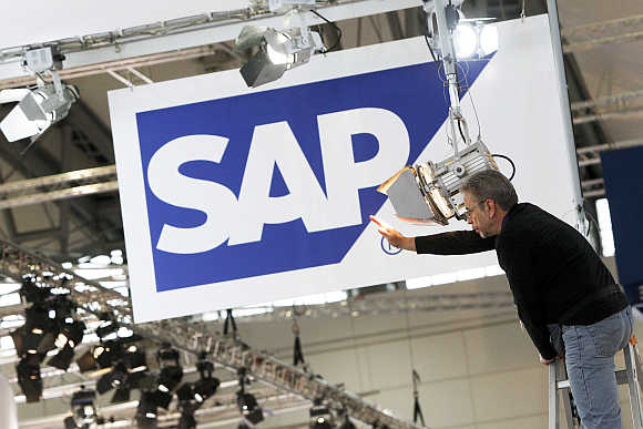 A worker adjusts a spotlight at the SAP booth in preparation for the CeBIT fair in Hannover, Germany.