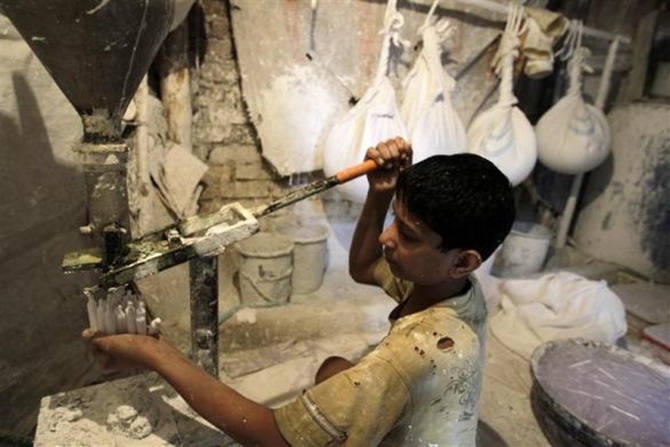 Ten-year old Murtaza works inside a lime paste factory in a slum area in Mumbai. 