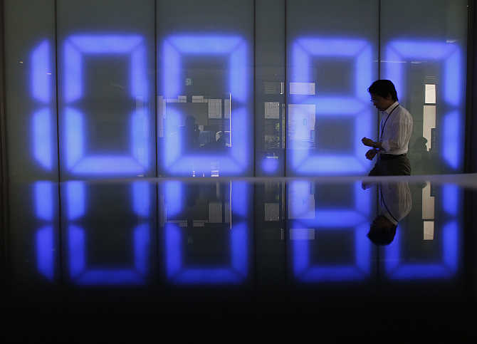 An employee of a foreign exchange company walks past a monitor displaying the Japanese yen's exchange rate against the US dollar in Tokyo. Photo is for representation purpose only.