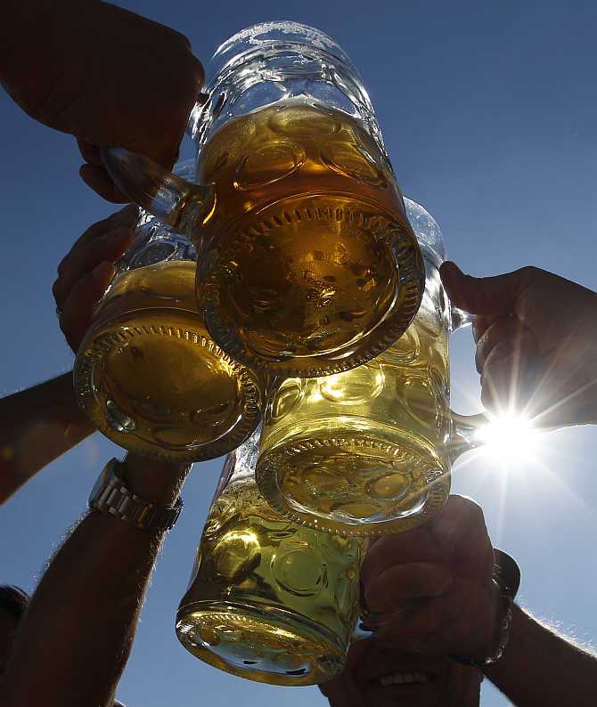 People toast with beer mugs at Munich's Oktoberfest in Germany.