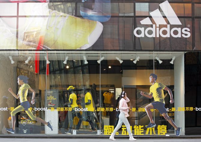 A woman walks past an Adidas shop at a shopping district in Beijing.
