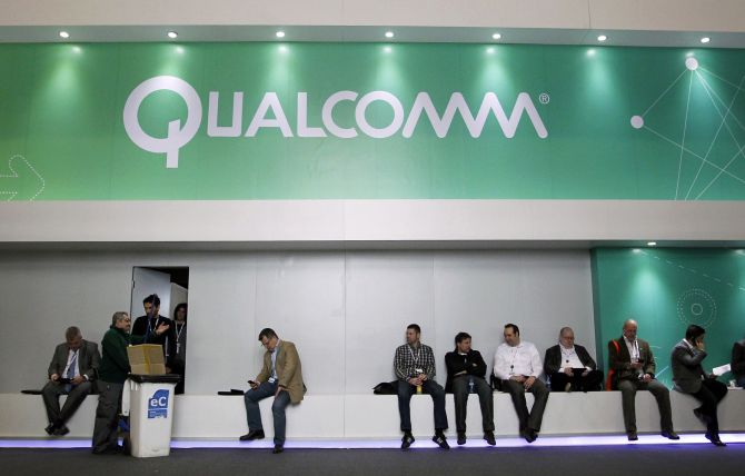 People sit next a Qualcomm stand at the Mobile World Congress at Barcelona.