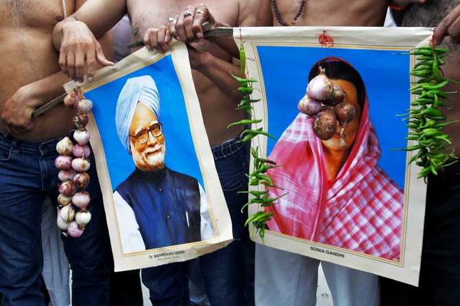Activists from Bharatiya Janata Party hold garlands of onions and green chillies around portraits of India's Prime Minister Manmohan Singh (left) and Congress party chief Sonia Gandhi during a protest against price hike in onions, in Allahabad.